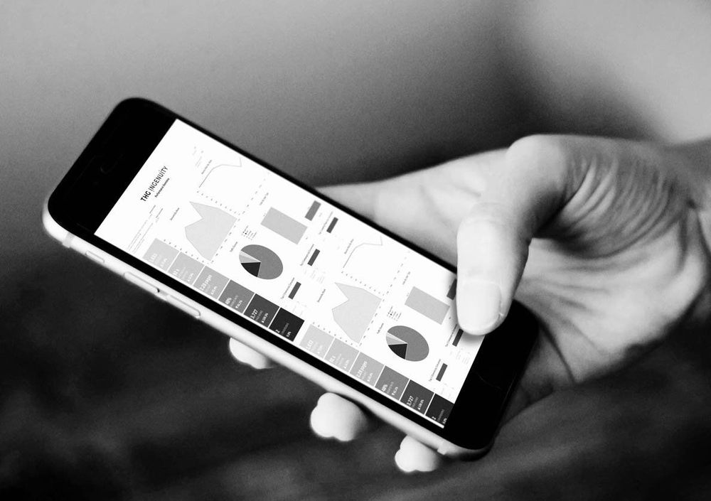a man holding a smartphone with graphs and charts on the screen