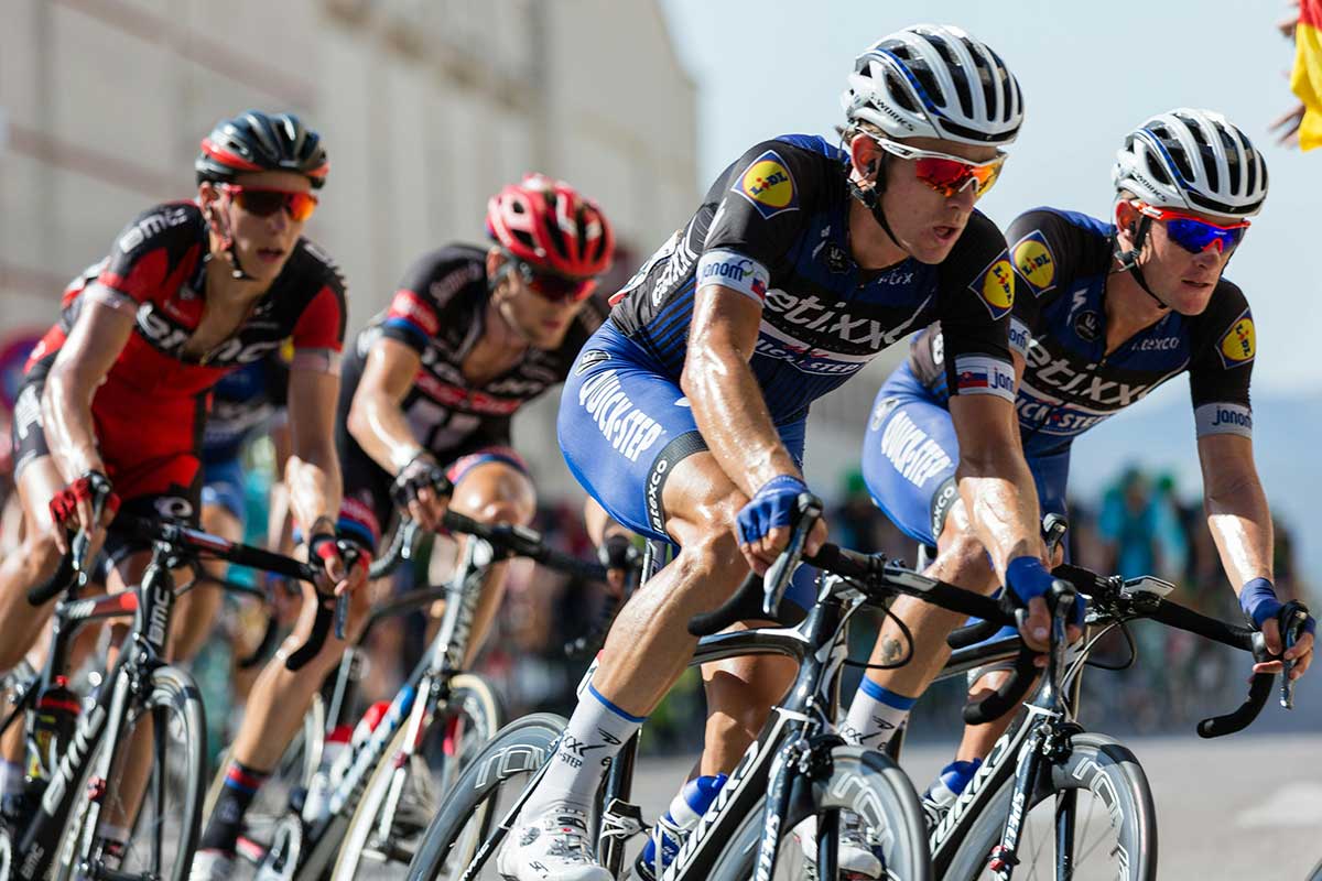 Cyclists racing outdoors, showing demand for sweat-resistant SPF formats in endurance sports.