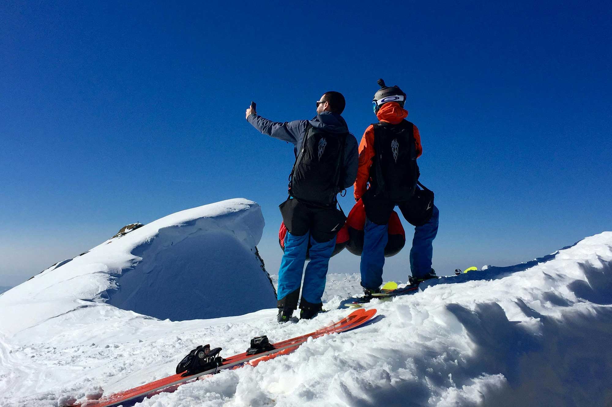 Skiers on snowy mountain summit, showing sun protection needs in high-altitude, cold environments.