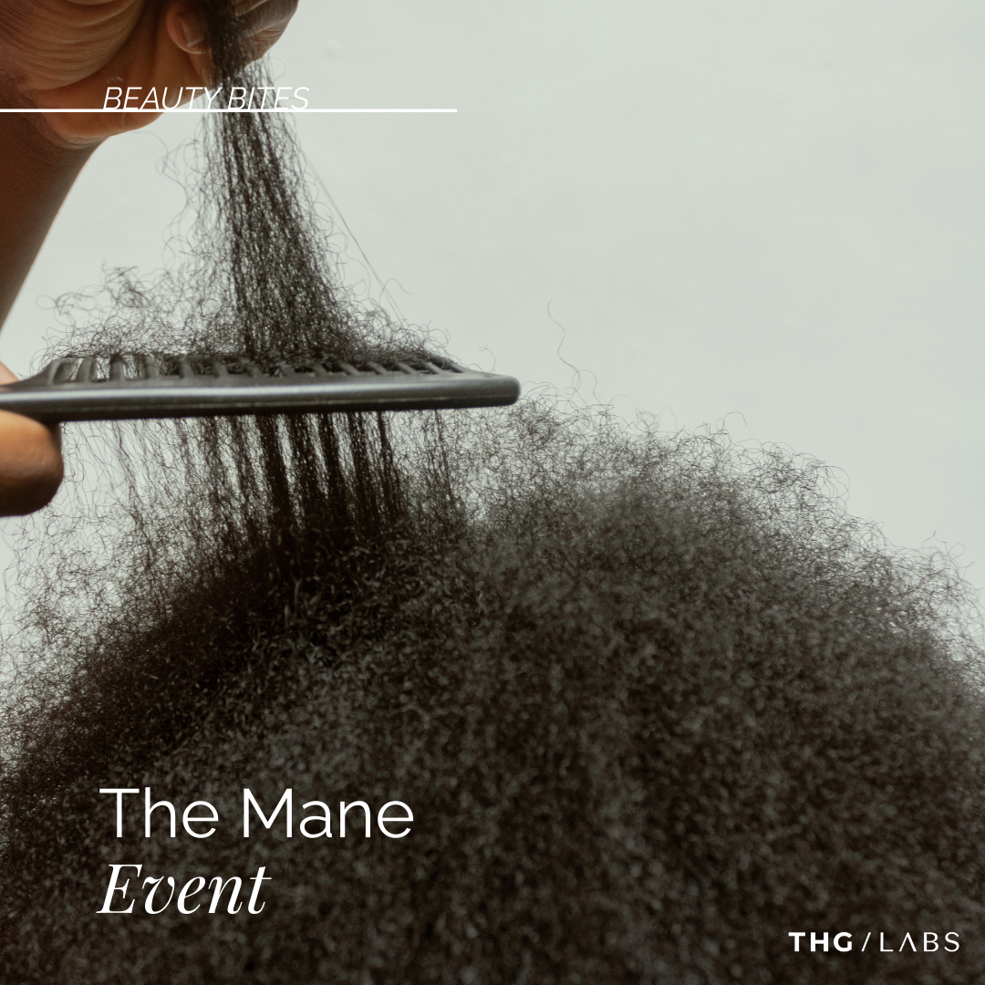 Close-up of Afro-textured hair being detangled with a comb.