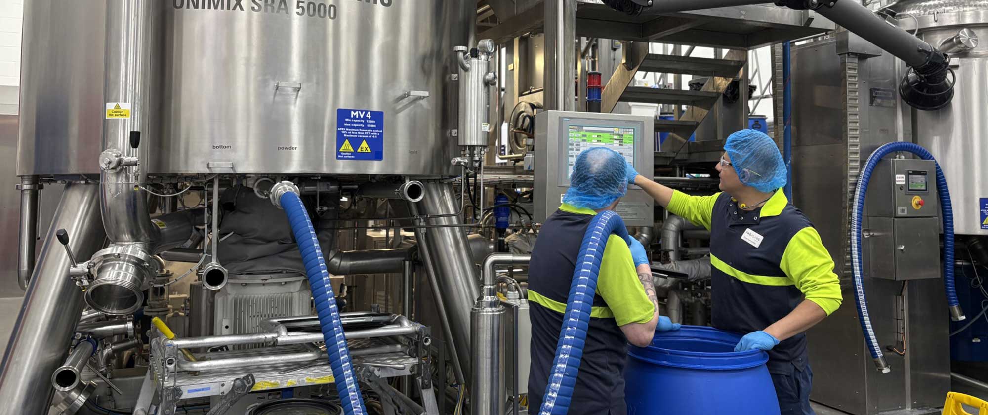 THG LABS bulk manufacturing team operating compounding vessel in advanced cosmetic production facility