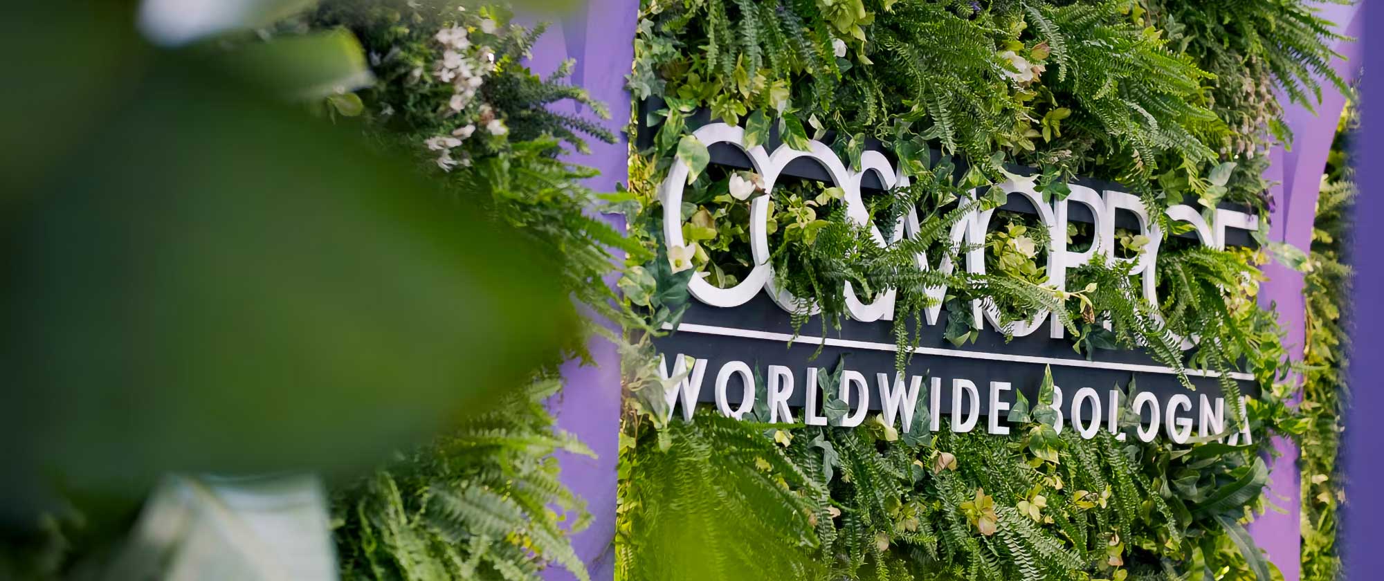 Cosmoprof Worldwide Bologna event signage surrounded by greenery highlighting global beauty industry innovation header