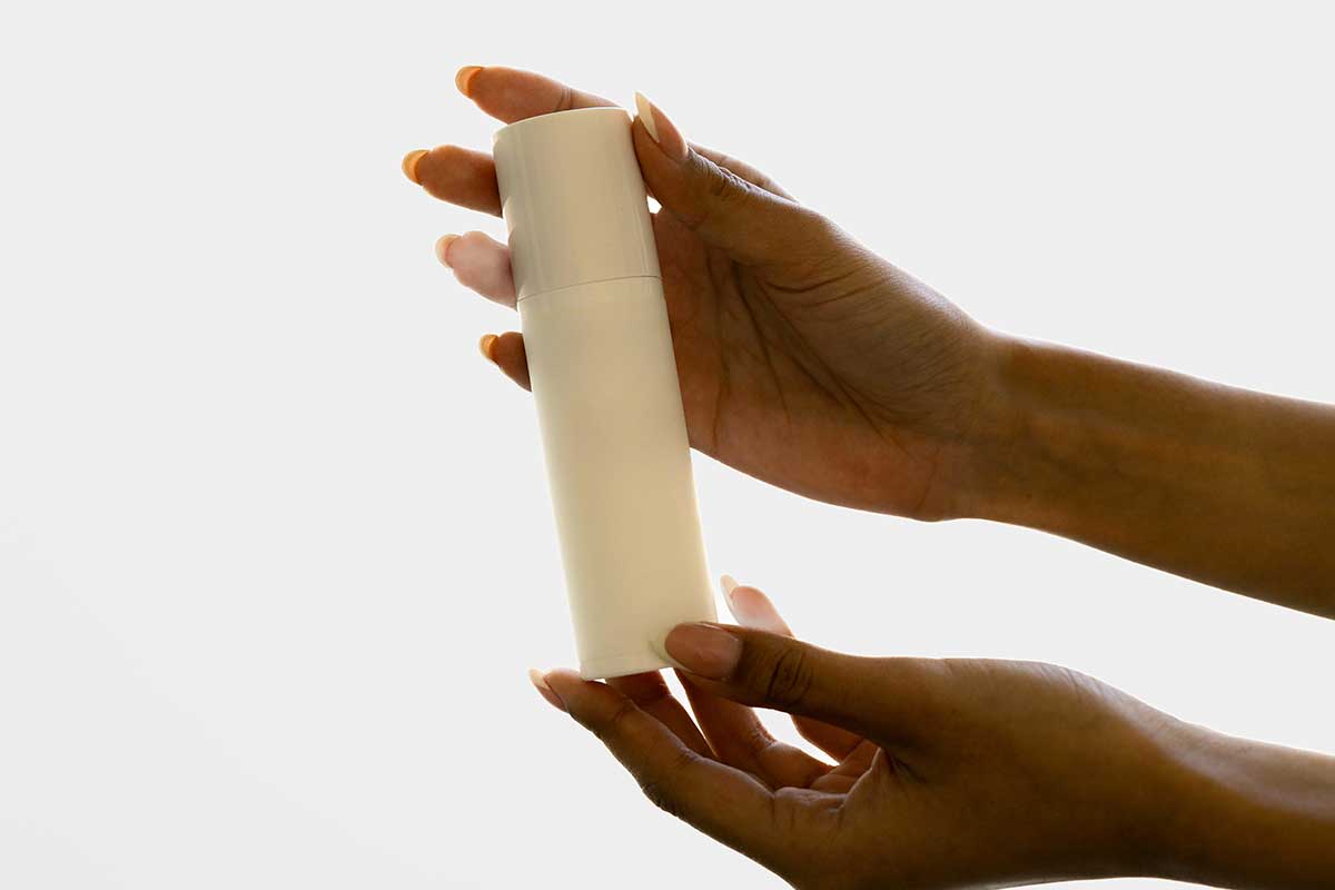 Premium haircare product packaging held in hand, representing science-led formulation development, product innovation and beauty manufacturing expertise.
