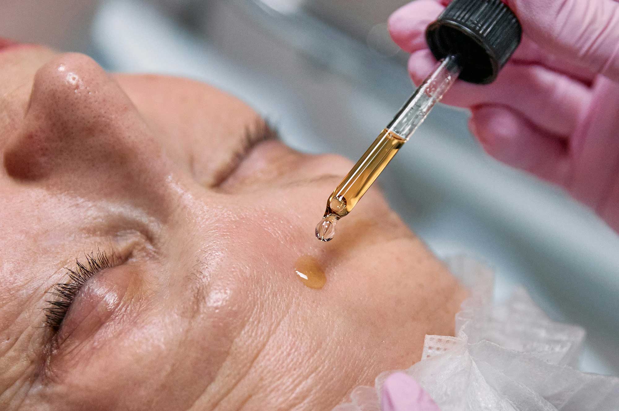 Professional serum application on mature skin showcasing advanced delivery systems in skincare formulation