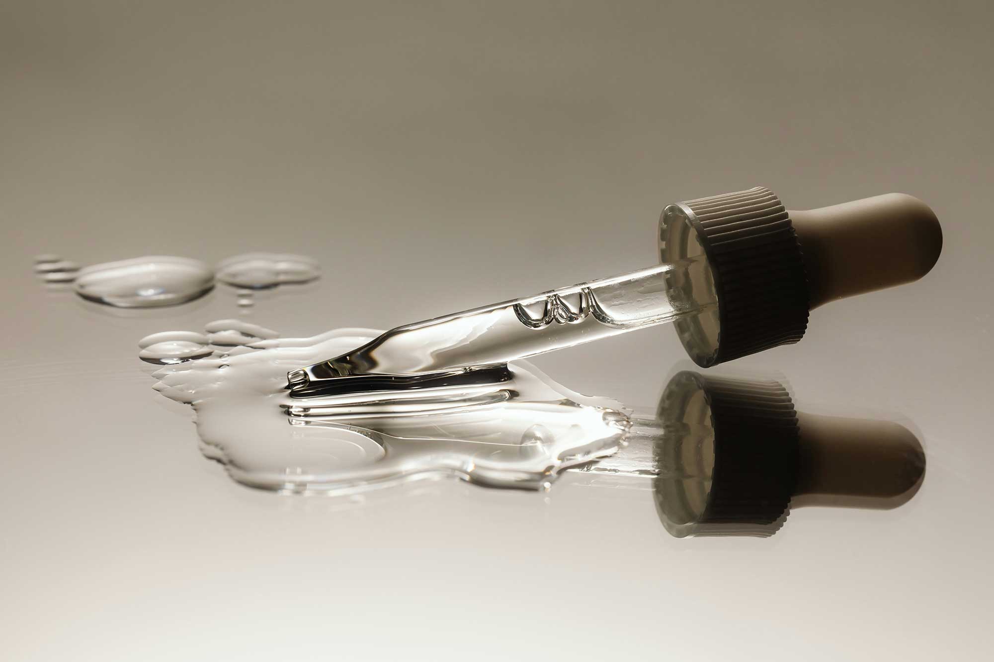 Close-up cosmetic serum pipette with liquid active ingredient, representing precision skincare formulation, efficacy-led product development and advanced beauty manufacturing at THG LABS.