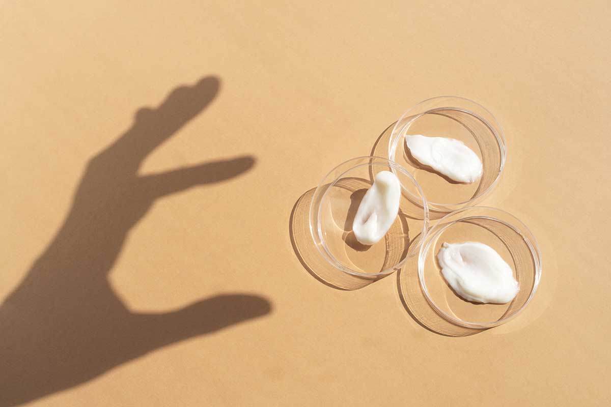 White cosmetic creams in clear sample dishes, illustrating bespoke body care formulation and customised cosmetic product development for beauty brands.