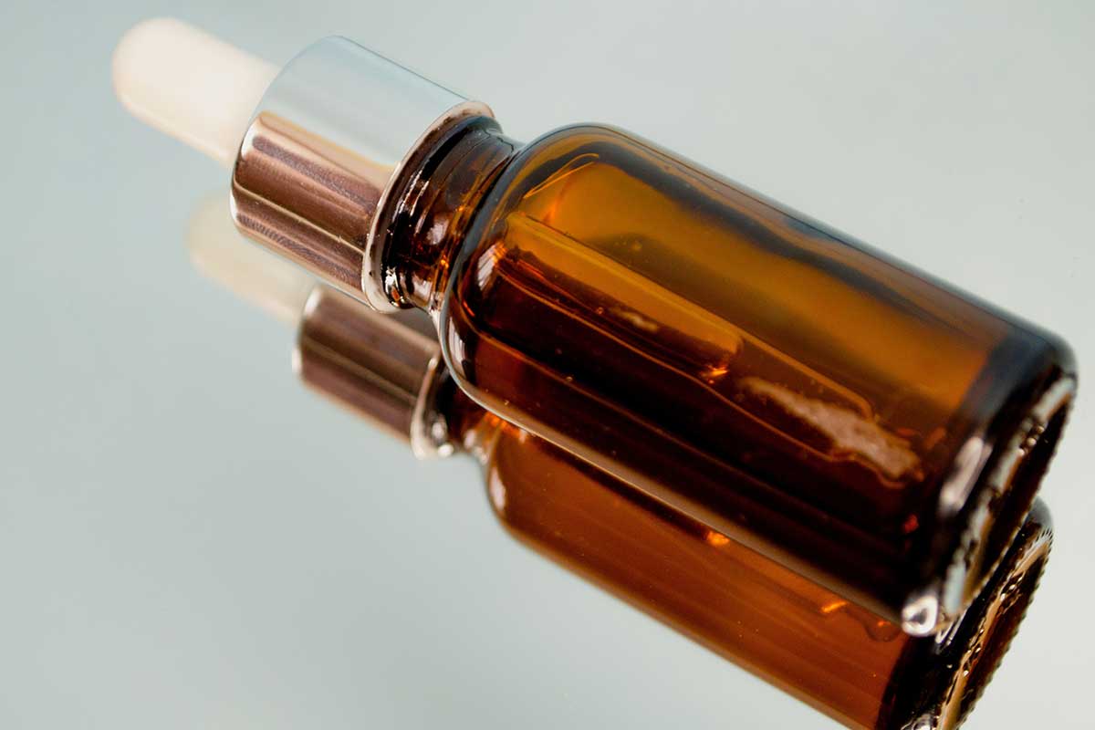 Amber cosmetic dropper bottle representing established beauty products being transferred to a new manufacturing partner.