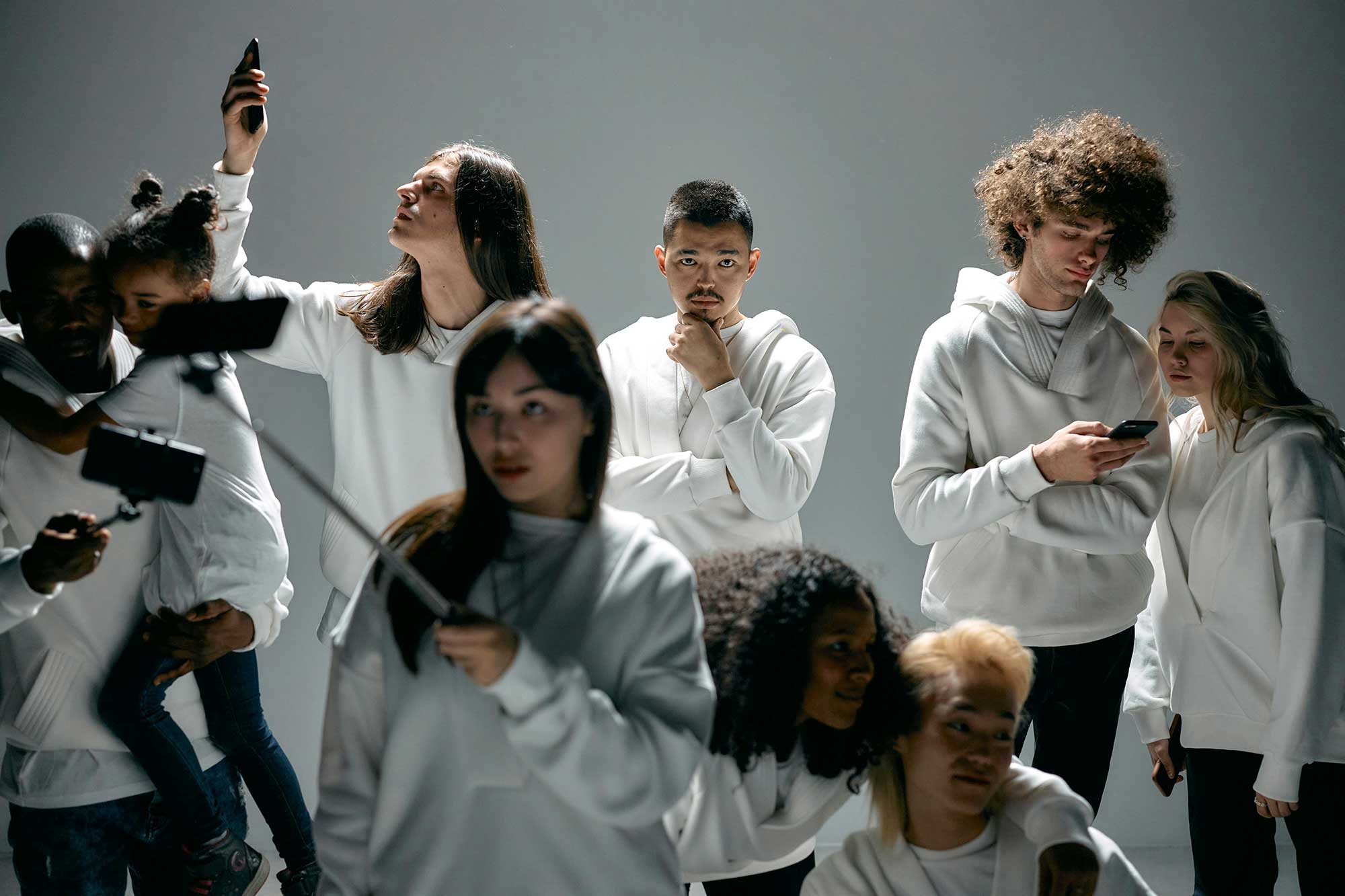 Diverse content creators and consumers using smartphones and digital devices, representing AI-driven beauty discovery, social commerce trends and the future of connected consumer engagement supported by THG LABS beauty manufacturing expertise.