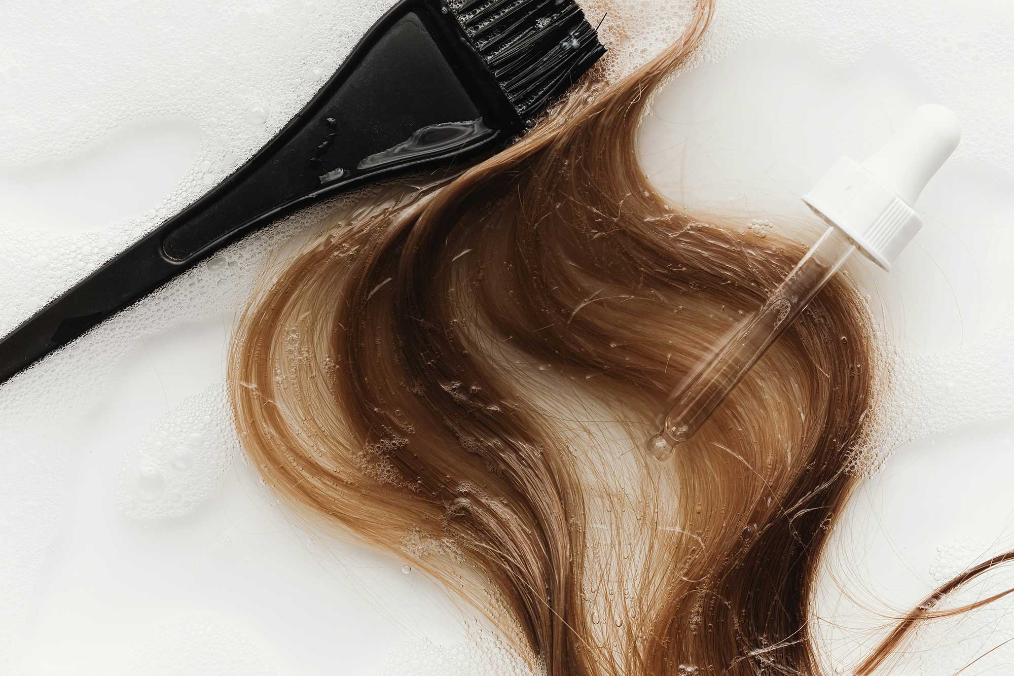 Close-up of hair strands with precision-applied active ingredients illustrating biotech innovation, clinically inspired haircare formulation and ingredient-led product development trends at THG LABS