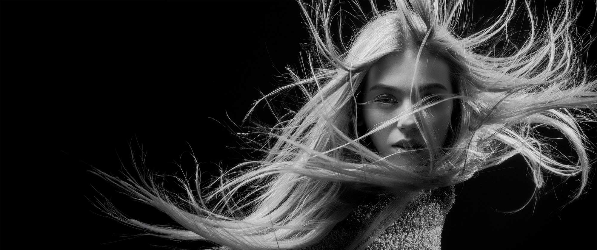 Model with wind-swept hair representing haircare innovation and product development expertise at THG LABS beauty manufacturing facilities