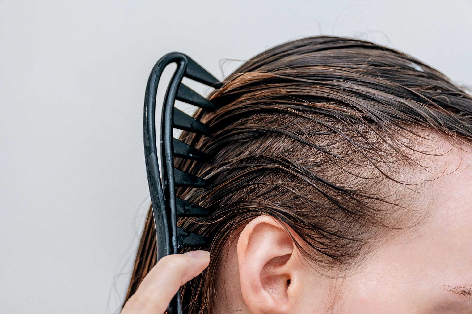 Consumer applying a scalp-focused haircare treatment as part of a multi-step wellness-led haircare ritual, reflecting premium haircare product development trends explored by THG LABS.