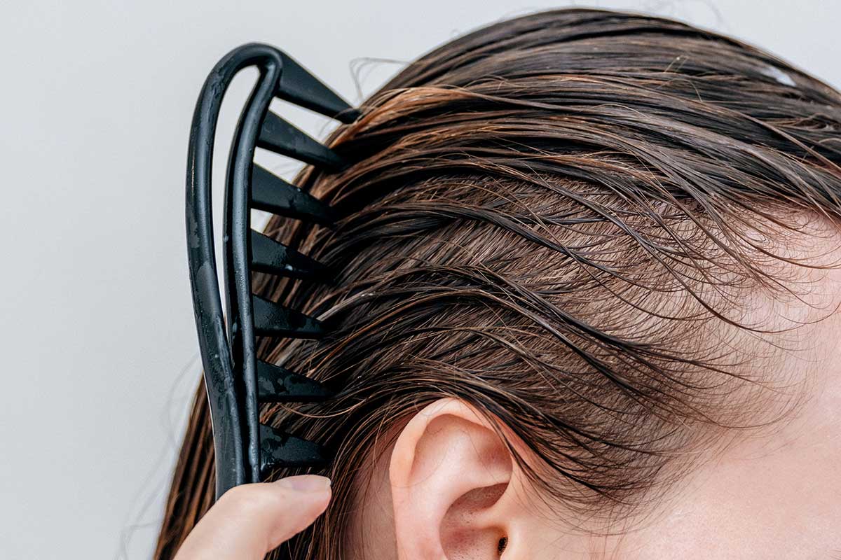 Consumer applying a scalp-focused haircare treatment as part of a multi-step wellness-led haircare ritual, reflecting premium haircare product development trends explored by THG LABS.
