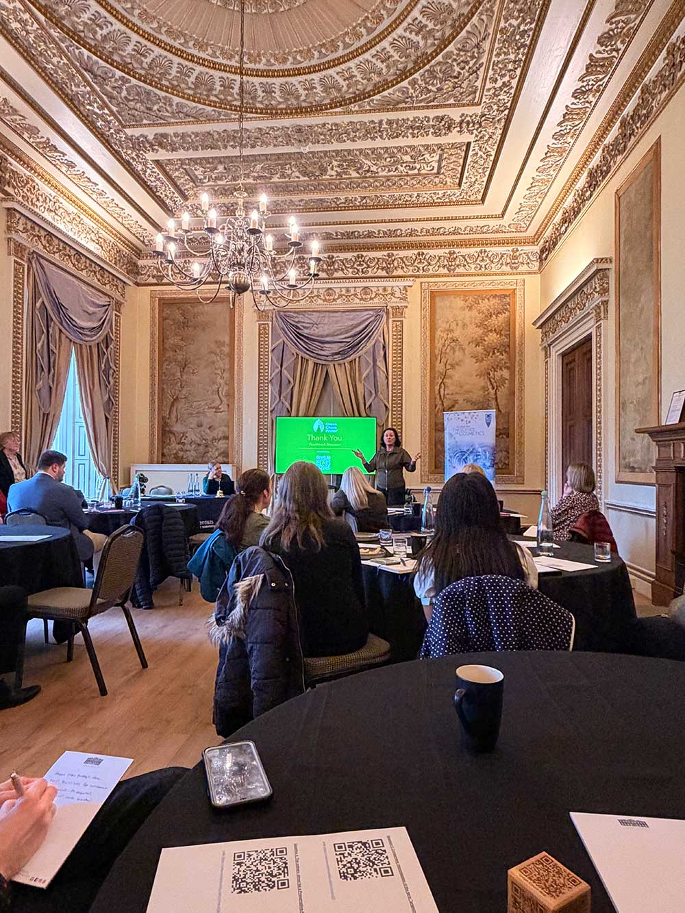 Beauty industry professionals attending Society of Cosmetic Scientists presentation at formal conference setting