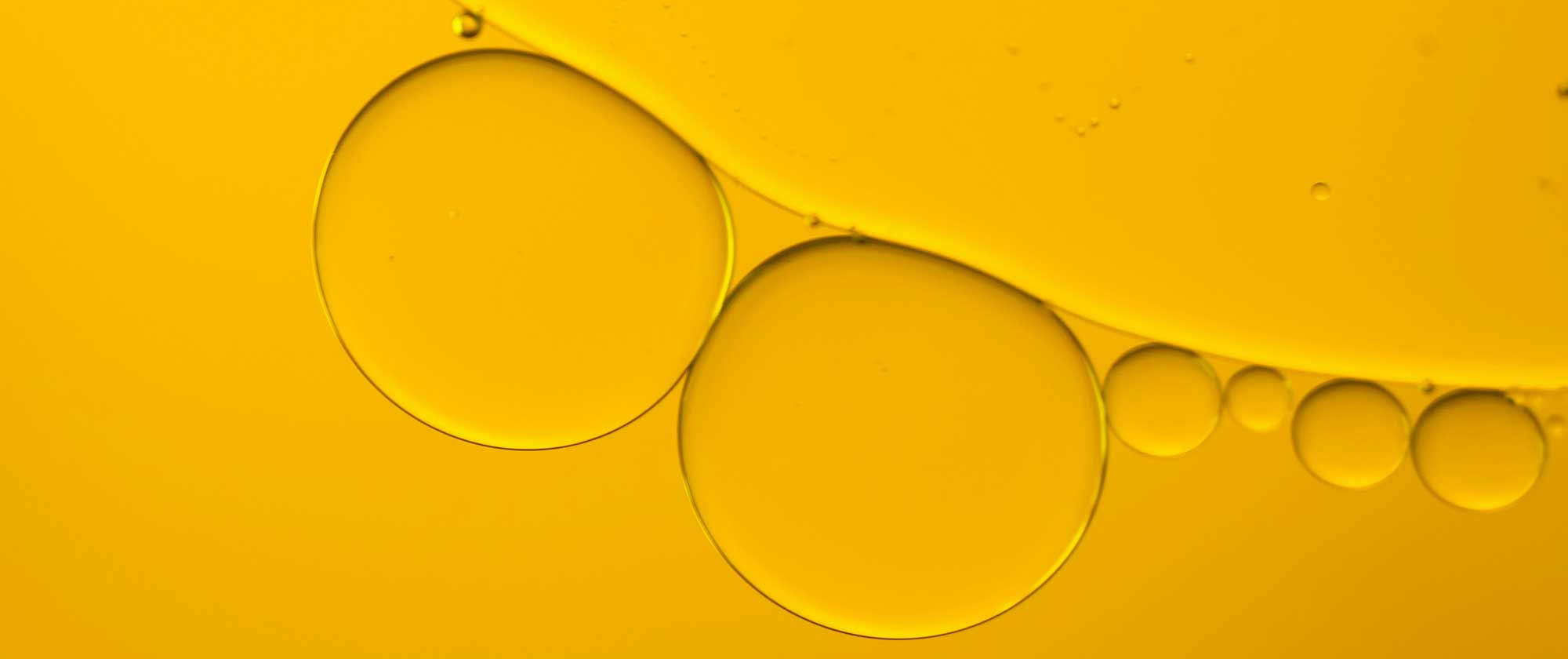 Oil droplets representing advanced skincare actives, antioxidants and peptides used in innovative SPF product development for beauty brands.