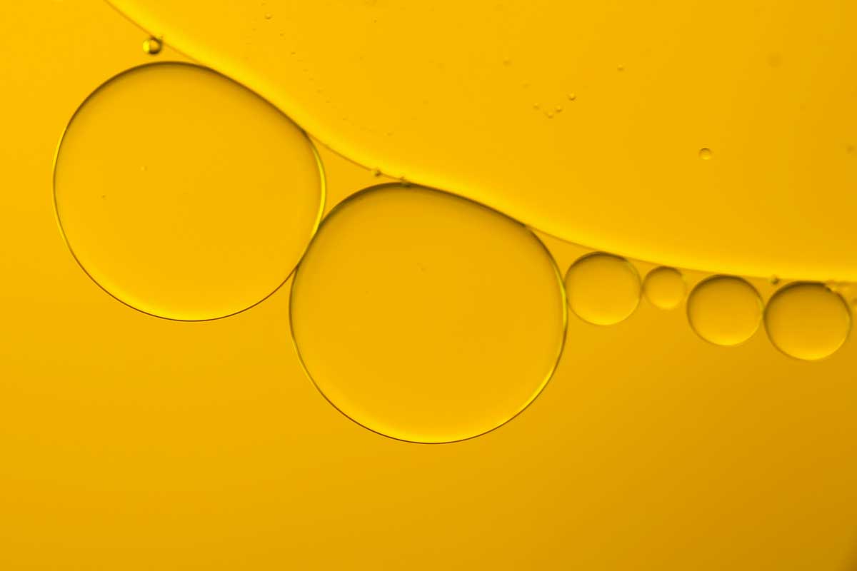 Oil droplets representing advanced skincare actives, antioxidants and peptides used in innovative SPF product development for beauty brands.