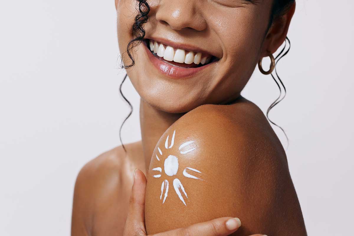 Woman with sun motif on shoulder illustrating THG LABS SPF skincare innovation and suncare product development for beauty brands.