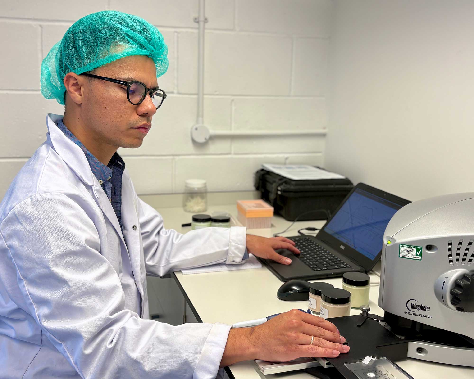 THG LABS suncare scientist using Labsphere UV-2000 technology for sunscreen analysis during SPF formulation development.